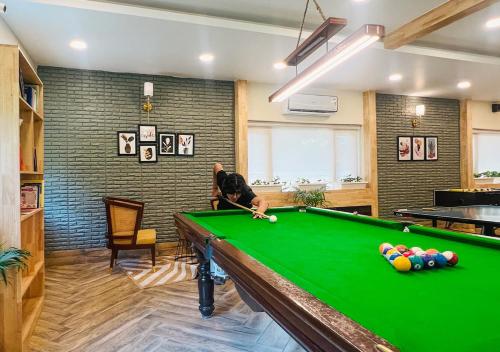 a man playing pool in a room with a pool table at The Solluna Resort in Marchula