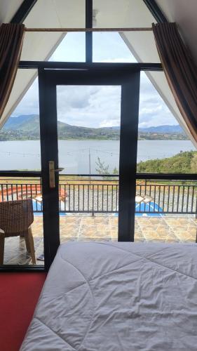 a room with a bed and a view of the water at Villa Annisa 2 in Alahanpanjang