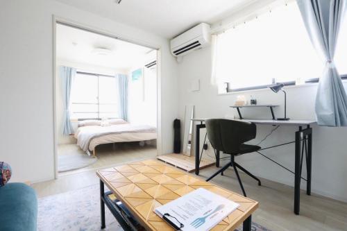 a living room with a table and a mirror at Comfort Boutique Room in Tokyo