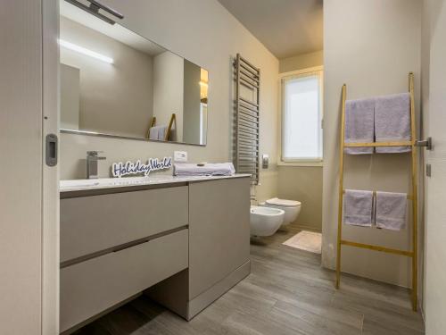 a bathroom with a sink and a toilet and a mirror at A Casa di Febe by Holiday World in Pisogne