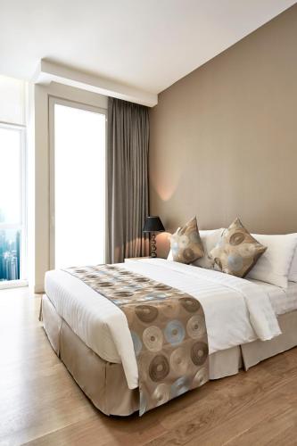 a bedroom with a large bed and a large window at THE FACE Suites Hotel in Kuala Lumpur