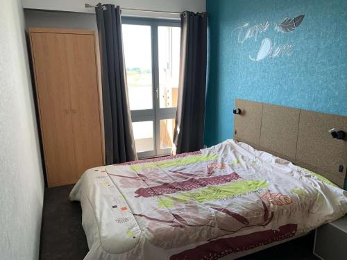 une chambre avec un lit dans une pièce avec une fenêtre dans l'établissement Le grand voilier Saint Hilaire de Riez, à Saint-Hilaire-de-Riez