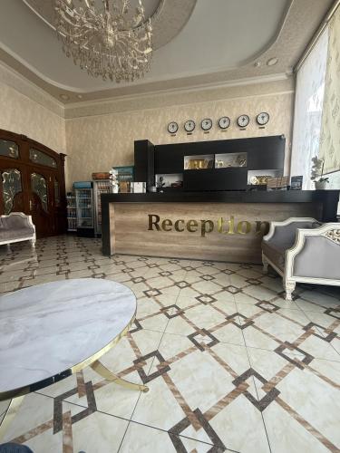 a lobby with a reception desk and a table at Reikartz Fergana in Fergana