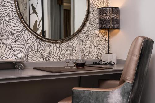 a desk with a mirror and a table with wine glasses at Golden Horse Hotel in Pietermaritzburg