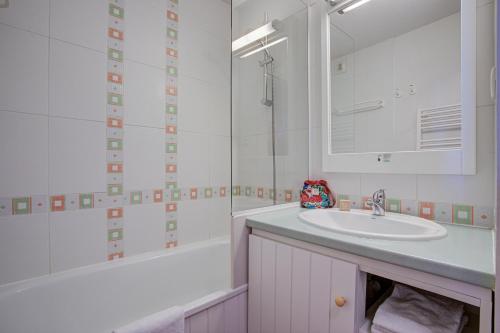 une salle de bain avec un lavabo, une baignoire et un miroir dans l'établissement Résidence Pierre & Vacances Le Pédrou, à Font-Romeu