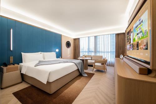 a hotel room with a bed and a television at 西安高新锦业路桔子水晶酒店 in Xi'an