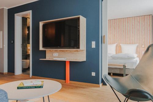 a living room with a tv on a blue wall at Silt & Sand Langeoog in Langeoog