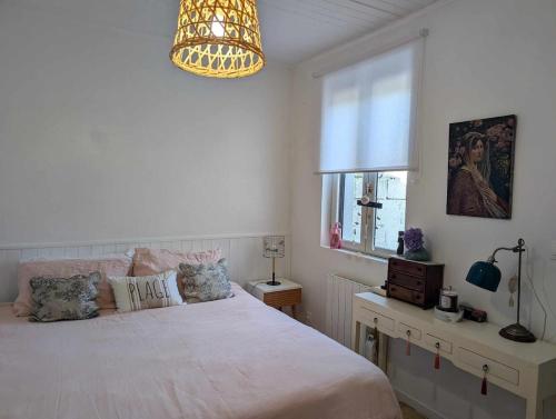 une chambre avec un grand lit et un lustre dans l'établissement La petite Rêverie, à Pornic