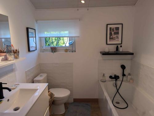 une salle de bain blanche avec un lavabo et des toilettes dans l'établissement La petite Rêverie, à Pornic