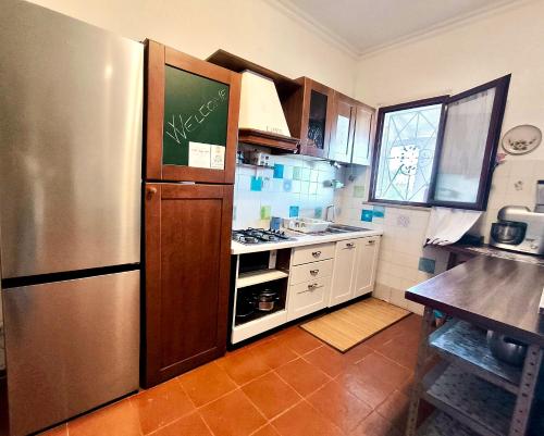 a kitchen with a stainless steel refrigerator and a table at Karma Rural Buenavista in Santa Marinella