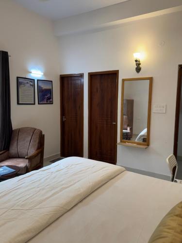 a bedroom with a bed and a mirror and a chair at Rootz in Dehradun
