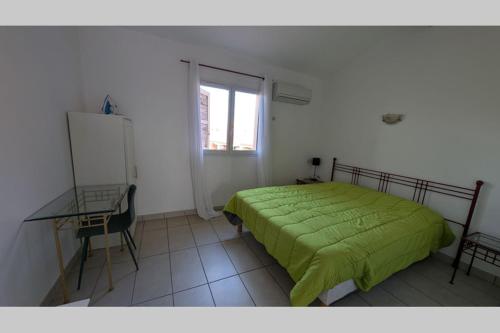 - une chambre avec un lit vert, un bureau et une fenêtre dans l'établissement Coquet T3 duplex - Sierra Nevada 245, à Canet