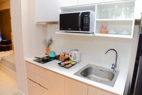a kitchen with a sink and a microwave at Veranda Residence Pattaya Nice Monthly rate available now in Na Jomtien