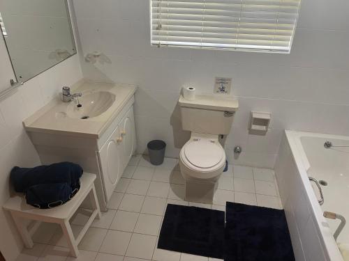 a bathroom with a toilet and a sink and a tub at Knysna's Rest in Brenton-on-Sea