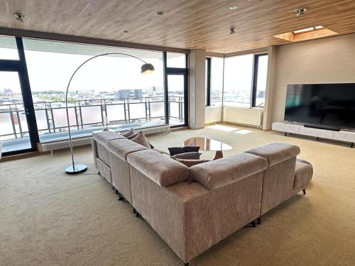 a large living room with a couch and a television at Cooee函館byTAKADAYA in Hakodate