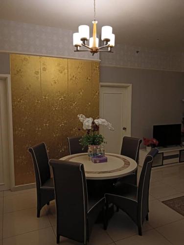 a dining room with a table and chairs and a chandelier at My Residence Villa Times Square KL in Kuala Lumpur