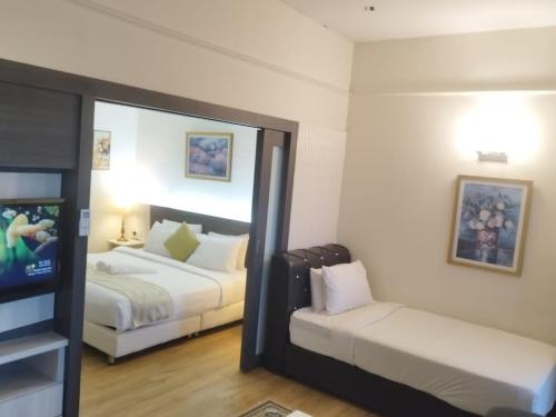 a hotel room with two beds and a mirror at My Residence Villa Times Square KL in Kuala Lumpur