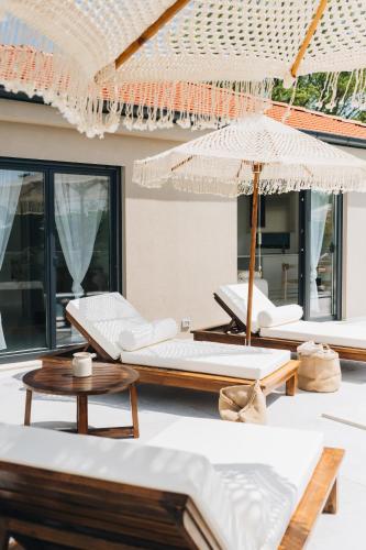 a group of chairs and umbrellas on a patio at NEW!!! Maison Mandri with Private Pool in Marasi