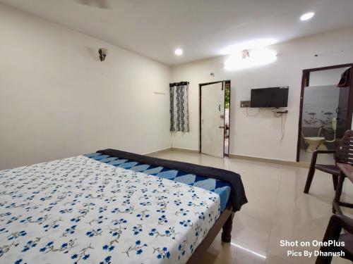 a bedroom with a bed with a blue and white comforter at Annamaiah Guest House & Homestay - Tirupati - Home Food Service in Tirupati