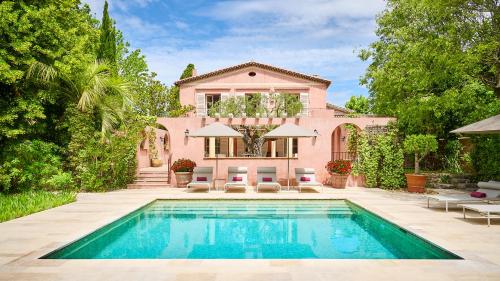 a pink house with a swimming pool in front of it at Le Pigonnet - Esprit de France in Aix-en-Provence
