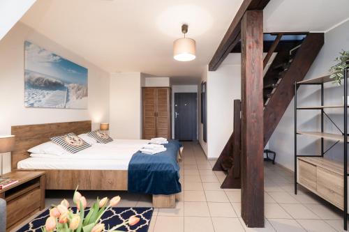 a bedroom with a bed and a staircase at Małe Morze in Chałupy