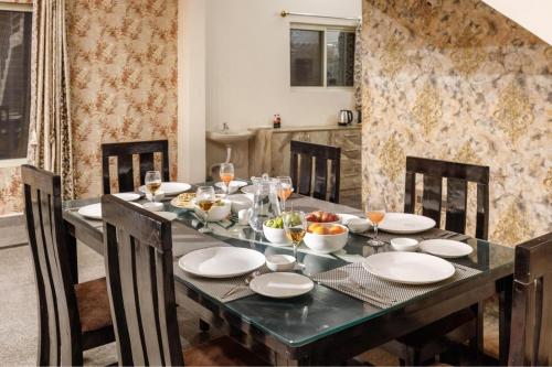 a dining room table with plates and bowls of food at Villa Exotica by StayJade5bhkPoolACProjector in Denkanikota