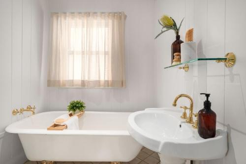a white bathroom with a tub and a sink at Little Forest Alpine Southern Highlands in Alpine