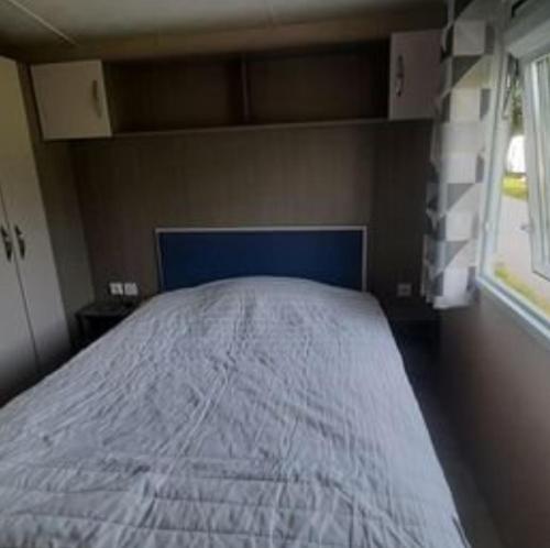 une chambre avec un lit dans une pièce avec une fenêtre dans l'établissement Mobil-Home de Matthieu & Elisa, à Pont-Scorff