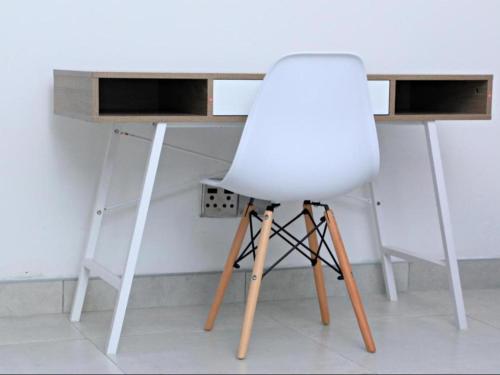 a white chair sitting in front of a desk at El-Gibbor Residence 1 in Ermelo