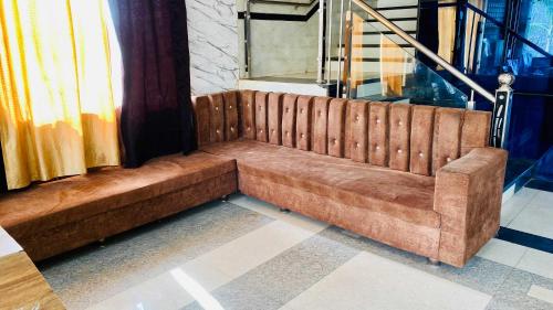 a brown couch sitting inside of a building at Hotel Palash in Godarpura