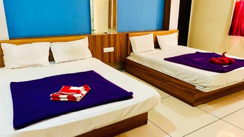 a bedroom with two beds with towels on them at Hotel Palash in Godarpura