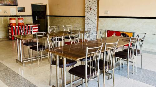 a dining room with wooden tables and chairs at Hotel Palash in Godarpura