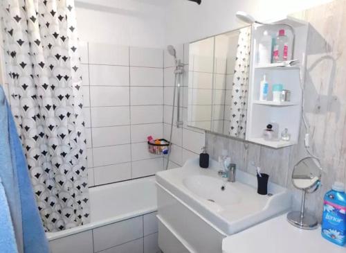 une salle de bain blanche avec un lavabo et un miroir dans l'établissement La vidita, à Marseille