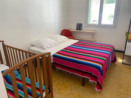 - une chambre avec un lit et une couverture colorée dans l'établissement Maison plus studio attenant tout équipé de plain pied climatisé 6CRSUD, à Canet
