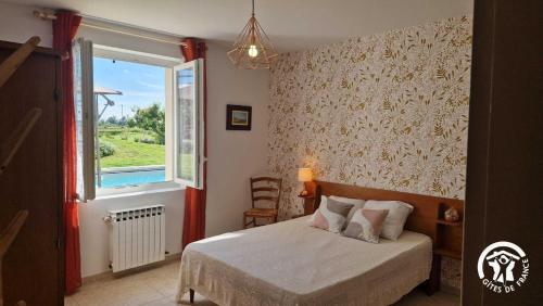 a bedroom with a bed and a window at La maison de prat coutel in Labastide-de-Lévis