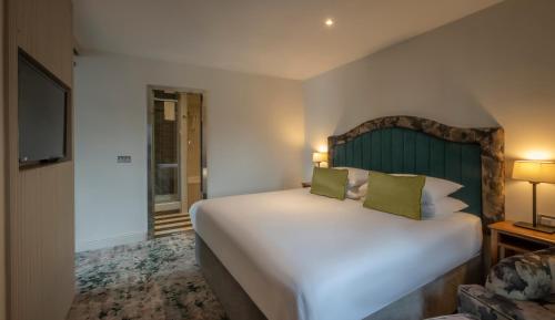 a bedroom with a large white bed and a television at The House Hotel, an Ascend Hotel Collection Member in Galway