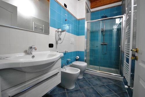 a bathroom with a sink and a toilet and a shower at Agriturismo Tenuta Kyrios con piscina in Borgagne