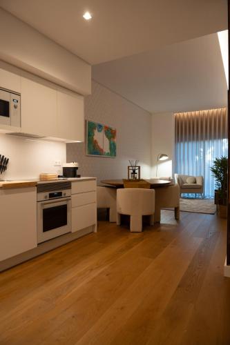 a kitchen with white cabinets and a table and a dining room at In-Town Residences in Funchal