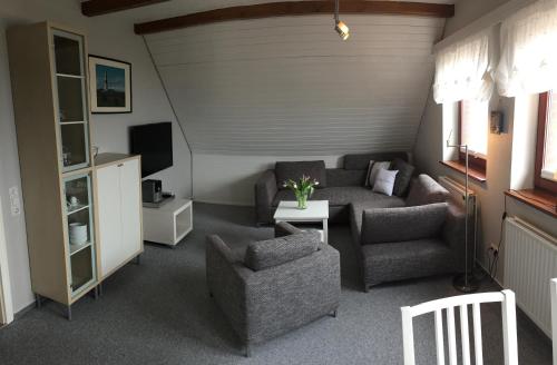 a living room with a couch and a chair at Zur Mühle Munkmarsch in Sylt