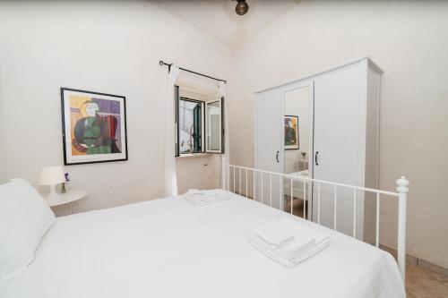 a white bedroom with a bed and a mirror at CASA PAPADIA in Uggiano la Chiesa