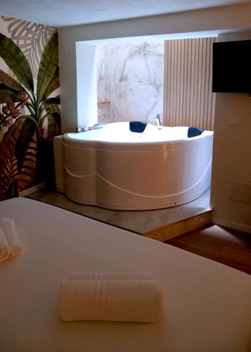 a bath tub in a bathroom with a sink at Agada Suite in Aci Castello