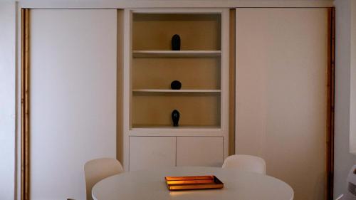 a white table with chairs and a white shelf at Agada Suite in Aci Castello