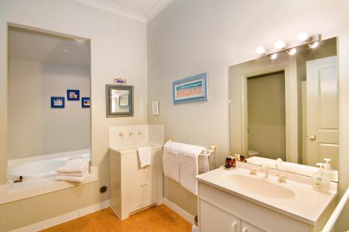
a bathroom with two sinks and a bathtub at Lemonade Creek Cottages in Lorne

