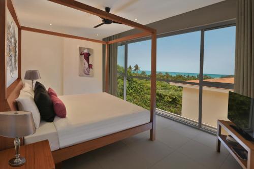 a bedroom with a bed and a large window at Samui Blue Orchid - Adult Only in Choeng Mon Beach