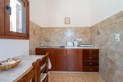 a kitchen with a counter and a sink and a table at Maria Apartments in Pefki Rhodes