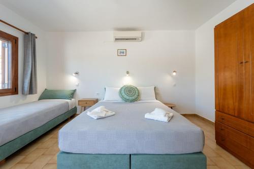 a bedroom with two beds and a dresser at Maria Apartments in Pefki Rhodes