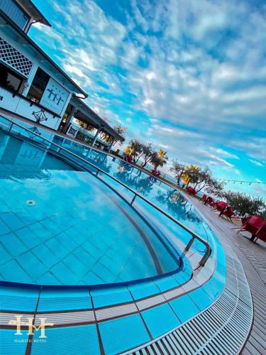 a large swimming pool with a blue sky in the background at Hotel Majestic in Durrës