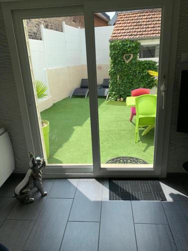 une chambre avec une porte coulissante en verre et une cour dans l'établissement Villa la Vie, Maison entière pour 4 personnes, avec extérieur, Tout inclus, ménage, linge, wifi, à Dieppe