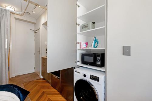 a kitchen with a washer and dryer in a room at Cityview Studio - Heart of Te Aro - Sleeps 2 in Wellington