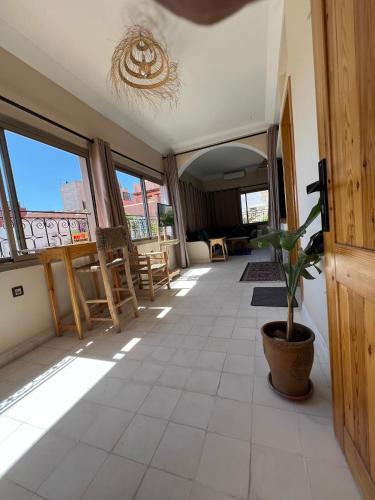 a room with a potted plant on a tiled floor at SurfAppart Morocco in Tamraght Ouzdar